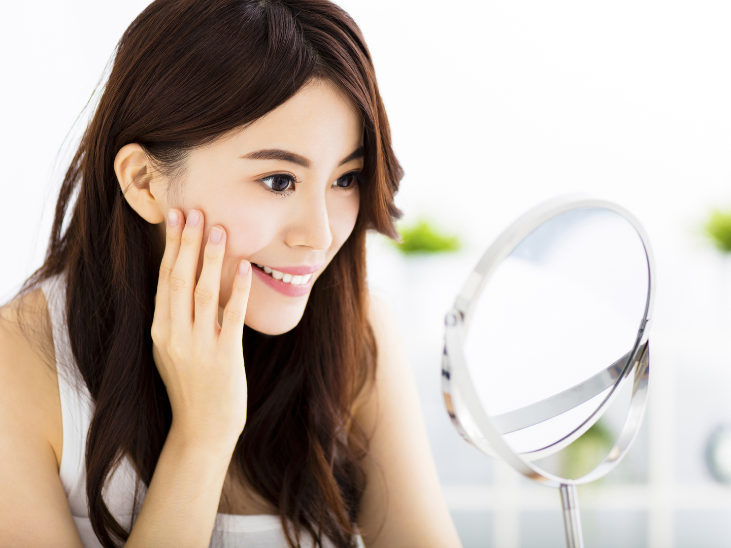 Happy young woman  looking on mirror