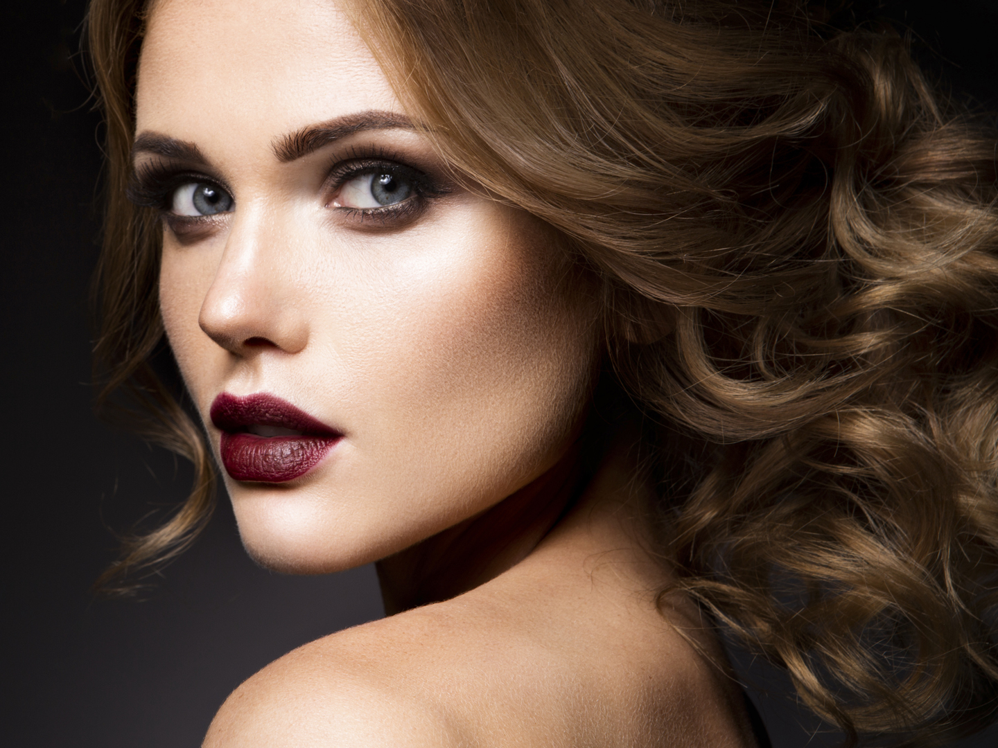 Close-up portrait of beautiful woman with bright make-up and dark red lips