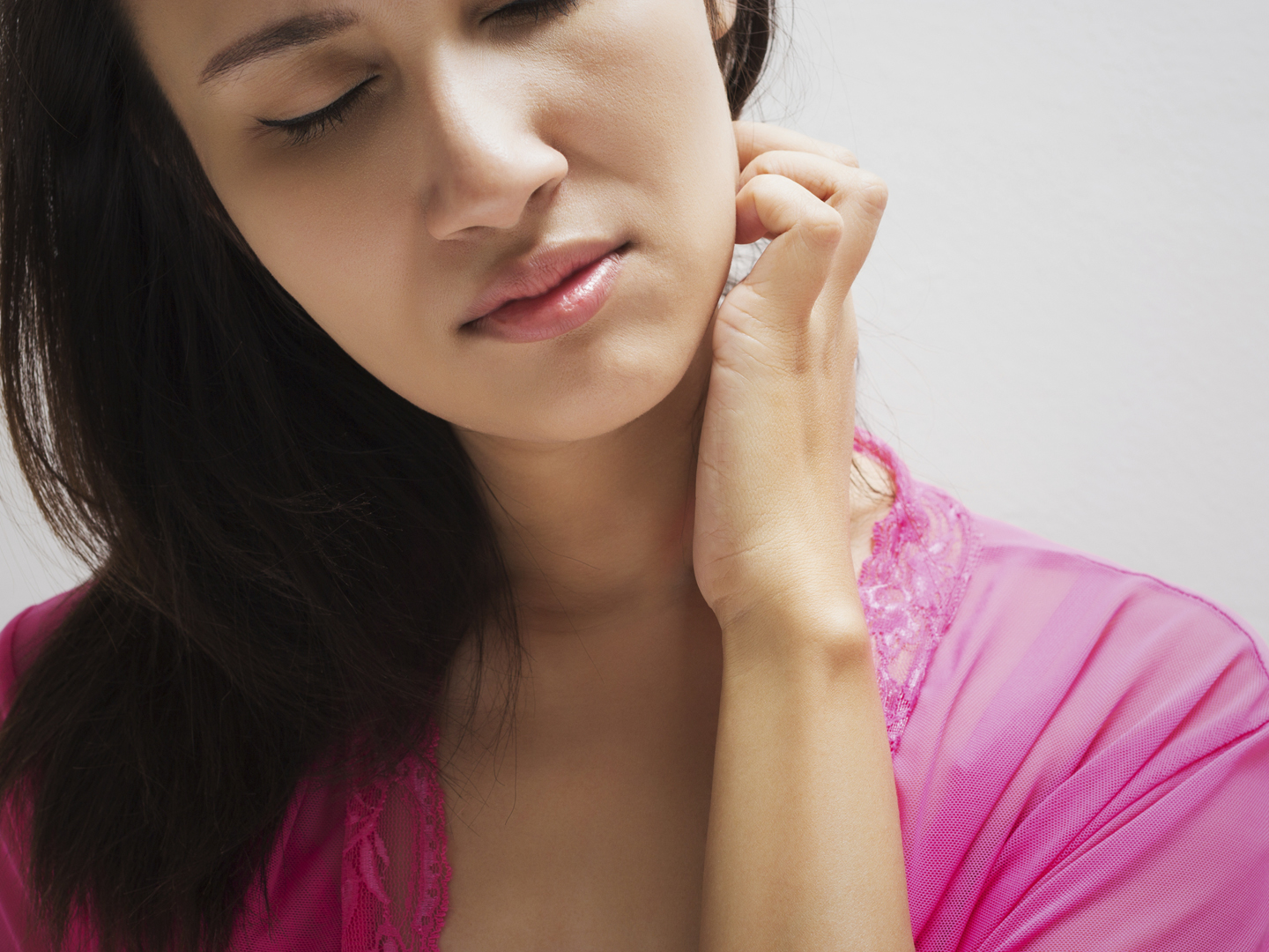 Young beautiful woman scraching her neck