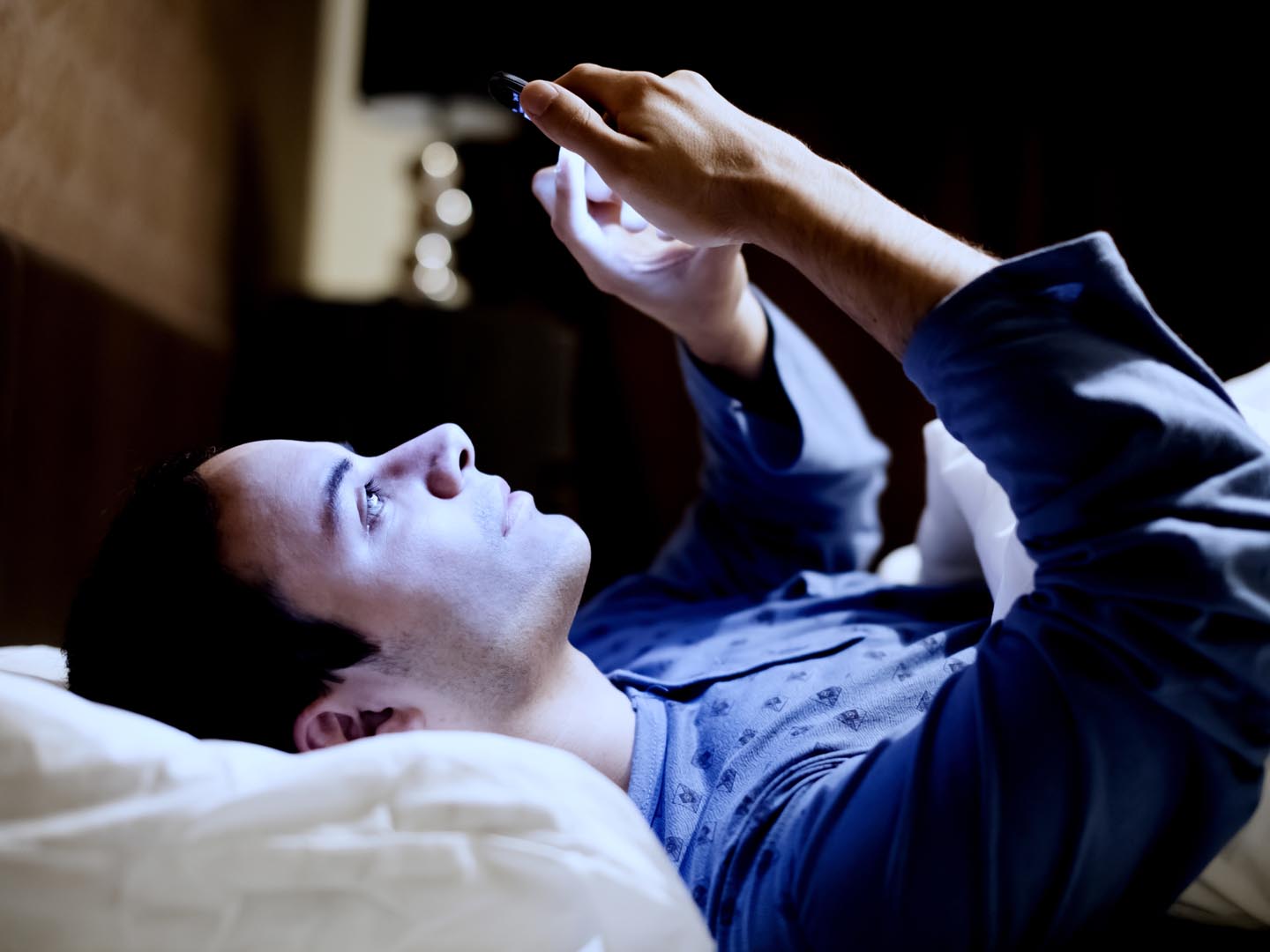 Man using his mobile phone in the bed