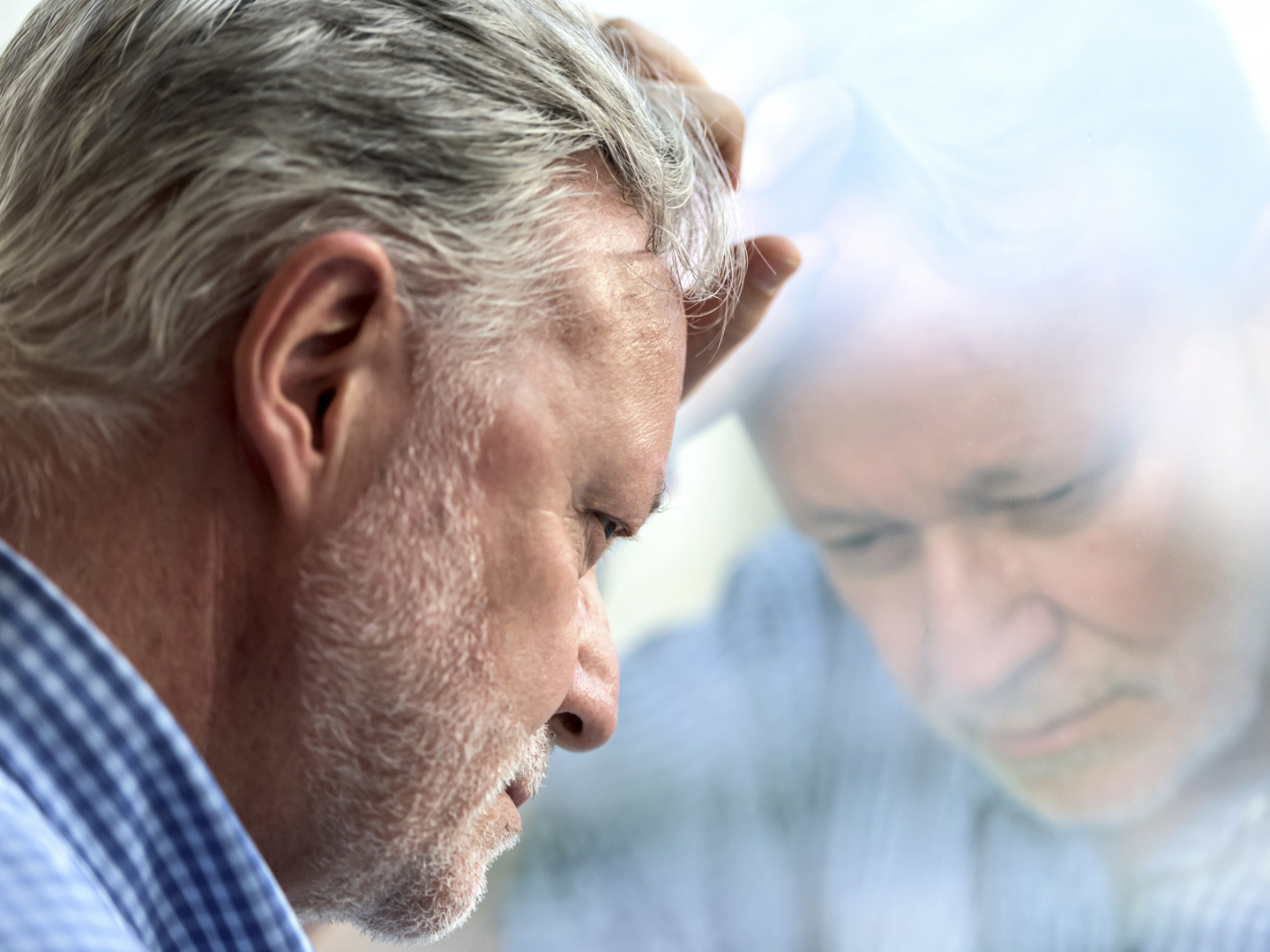 Serious concerned caucasian senior man posing looking down