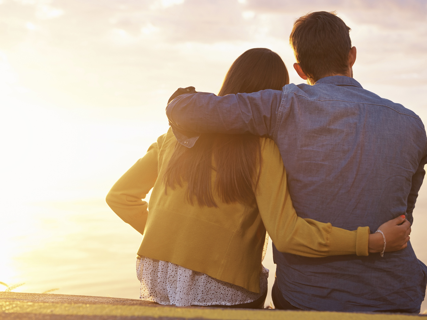 Rearview shot of a young couple looking at the sunset together