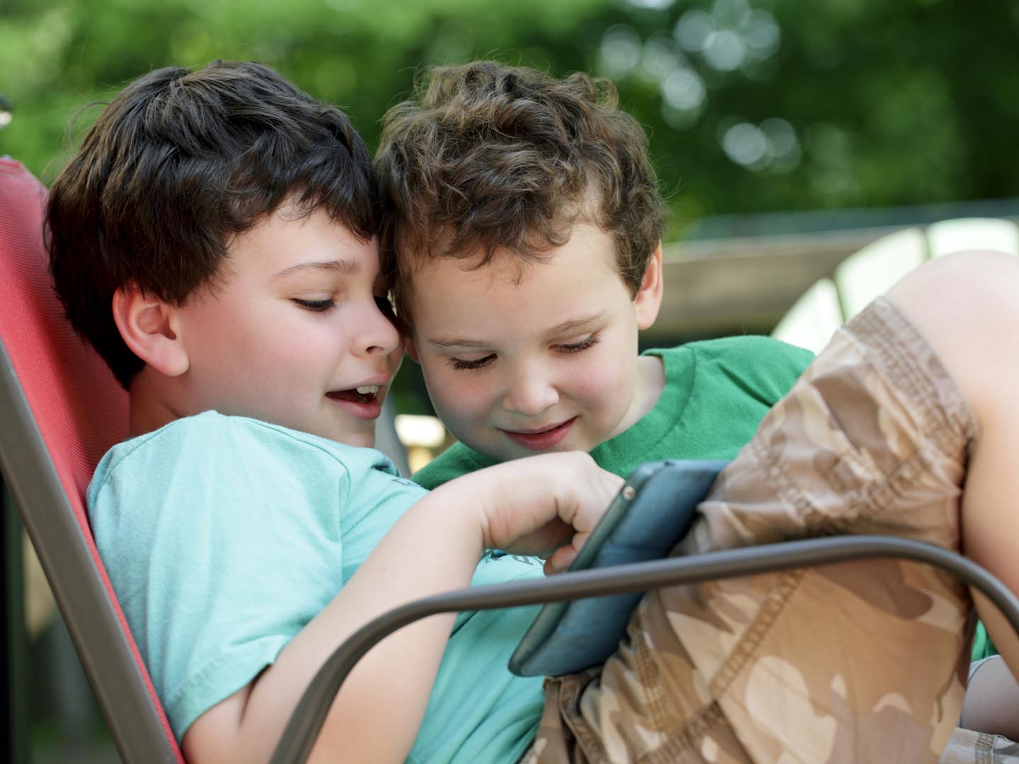 Two boys with special needs find they can tolerate closeness and sharing while engaged with apps on a computer tablet such as an iPad.