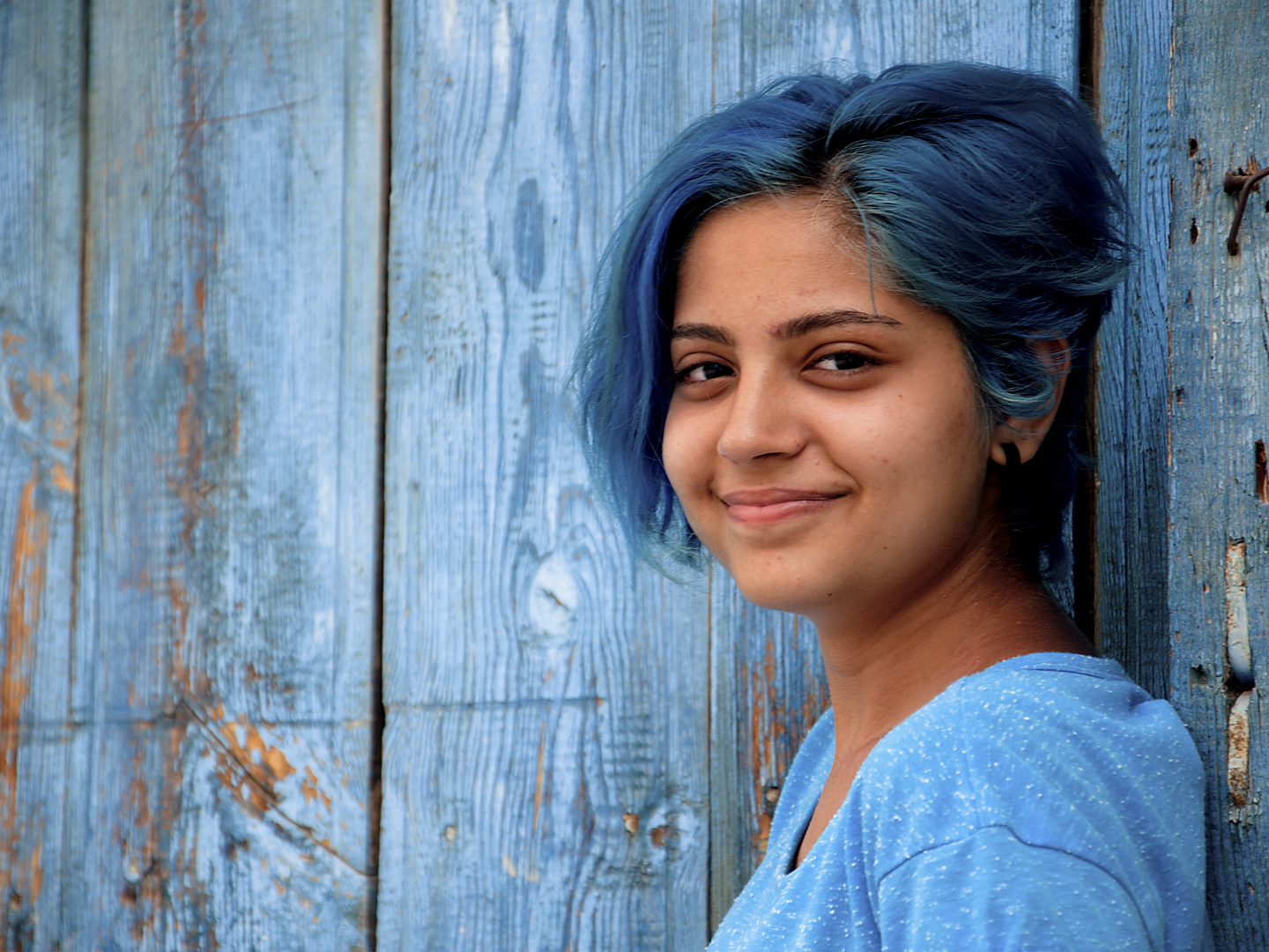 blue-haired young girl smiles