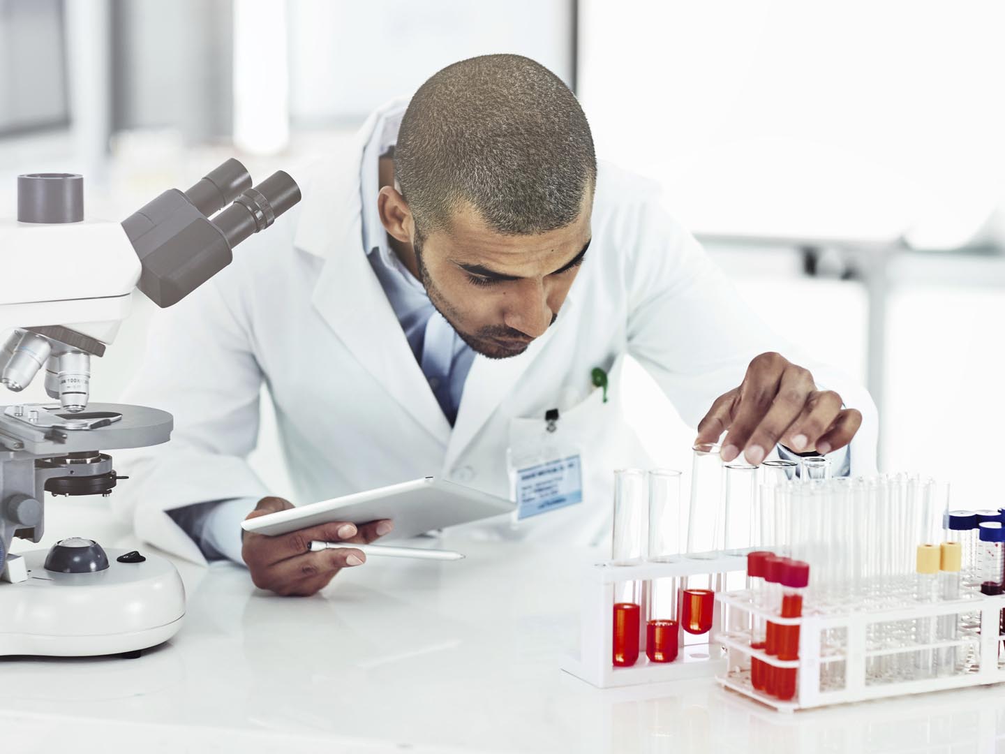 Shot of a male scientist examining a test tube filled with blood