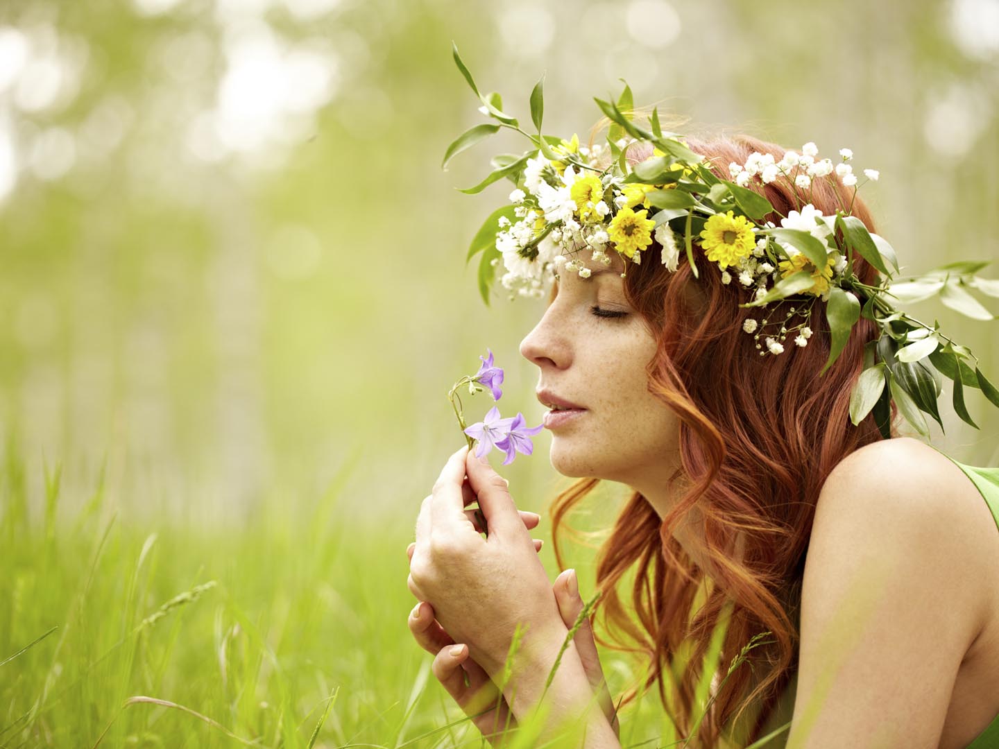 Beautiful woman admiring bluebell flower smell