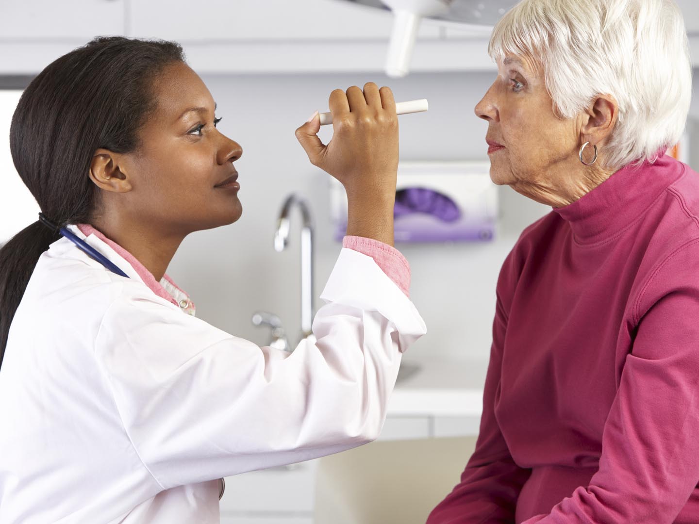 Female Doctor Examining Senior Female Patient&#039;s Eyes