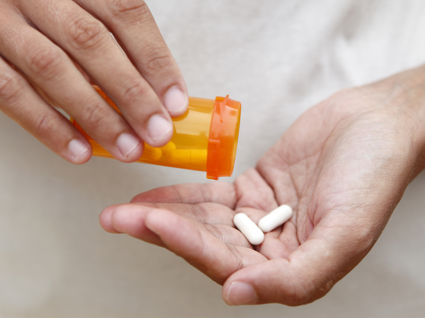 Women pouring medicine into hand.