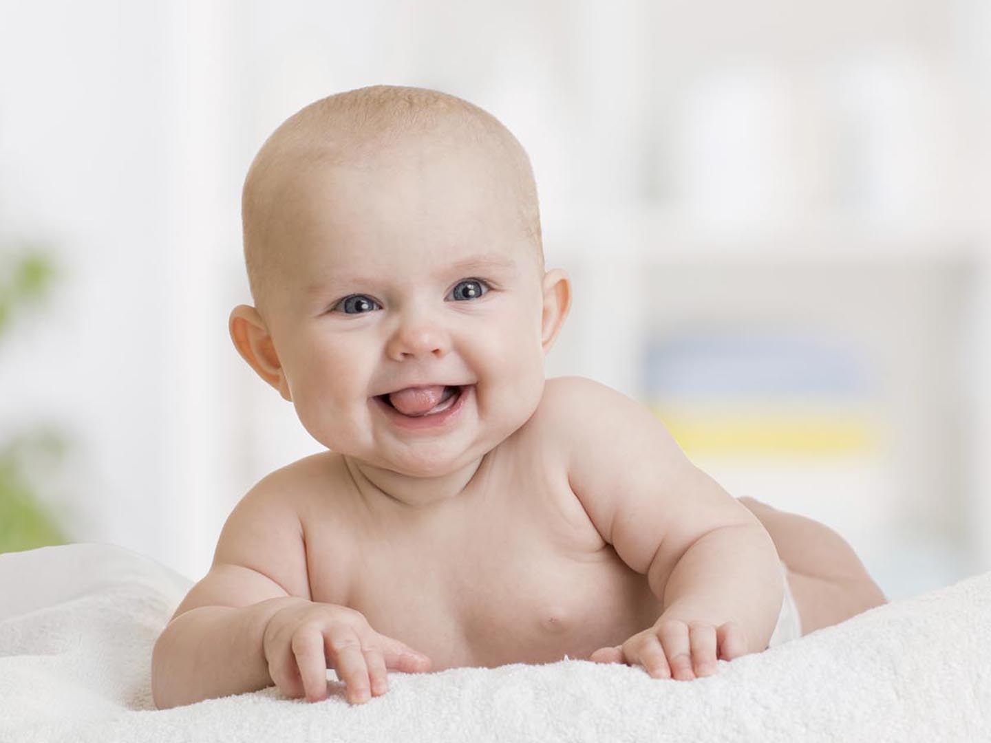 Cute smiling baby girl lying on towel