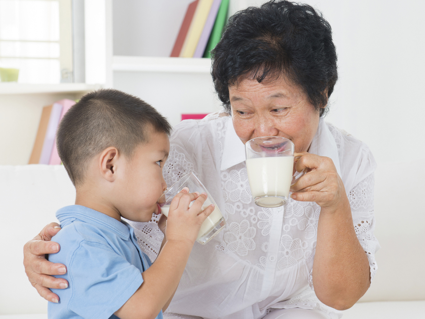 Drinking milk. Happy multi generations Asian family drinking milk at home. Beautiful grandmother and grandson, healthcare concept.