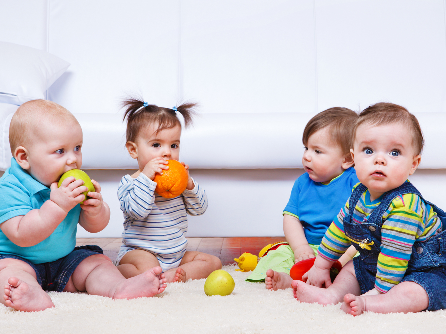 Four toddlers sitting in a lounge