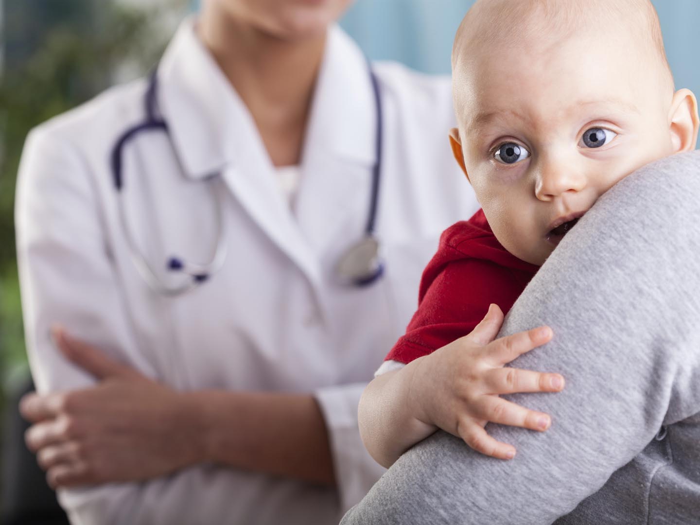 Close-up of a baby boy in the arms of mother at doctor&#039;s office