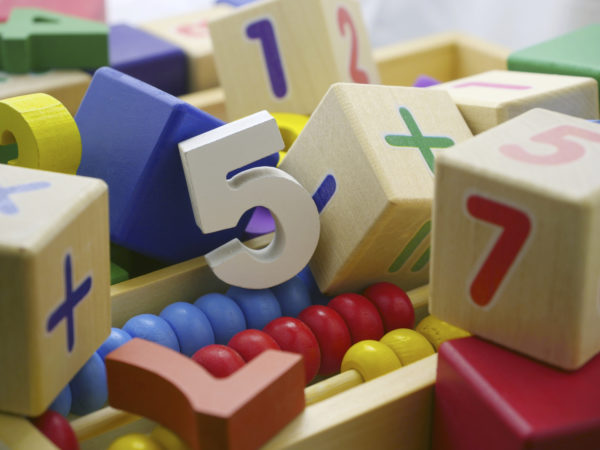 Wooden blocks and multicolor figures in a box.