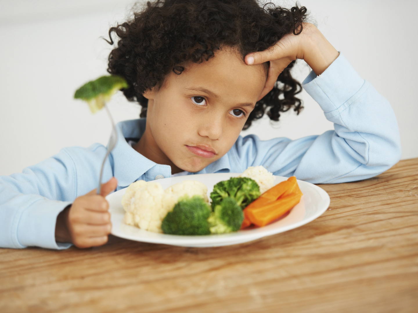 Shot of an unimpressed-looking little boy sitting in front of a plate of vegetableshttp://195.154.178.81/DATA/i_collage/pi/shoots/785154.jpg