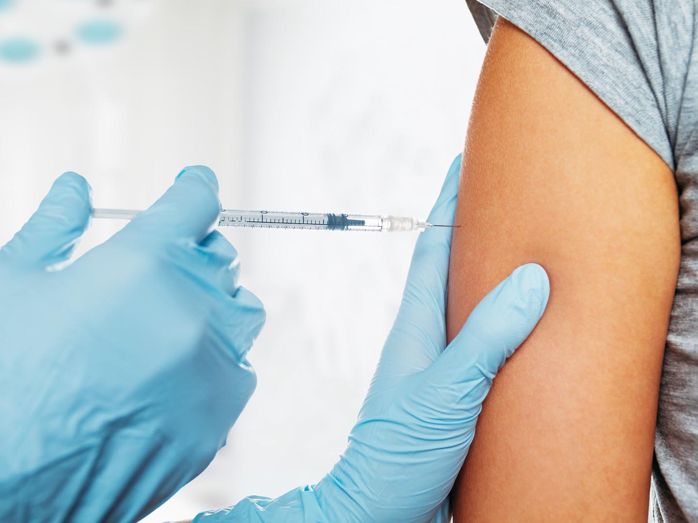 Nurse makes vaccination in the shoulder of patient in a clinic