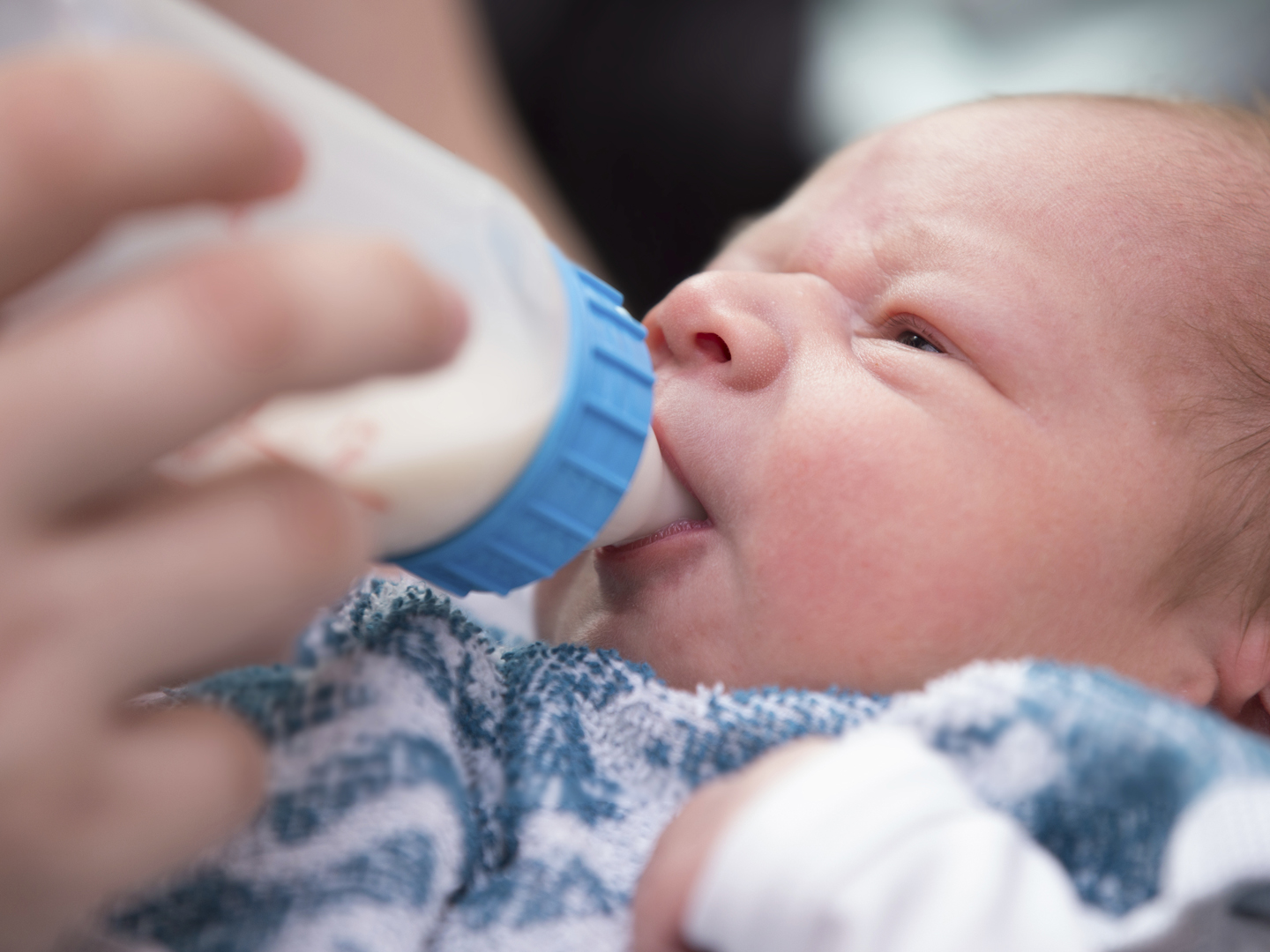 Newborn baby drinking bottle milk at night