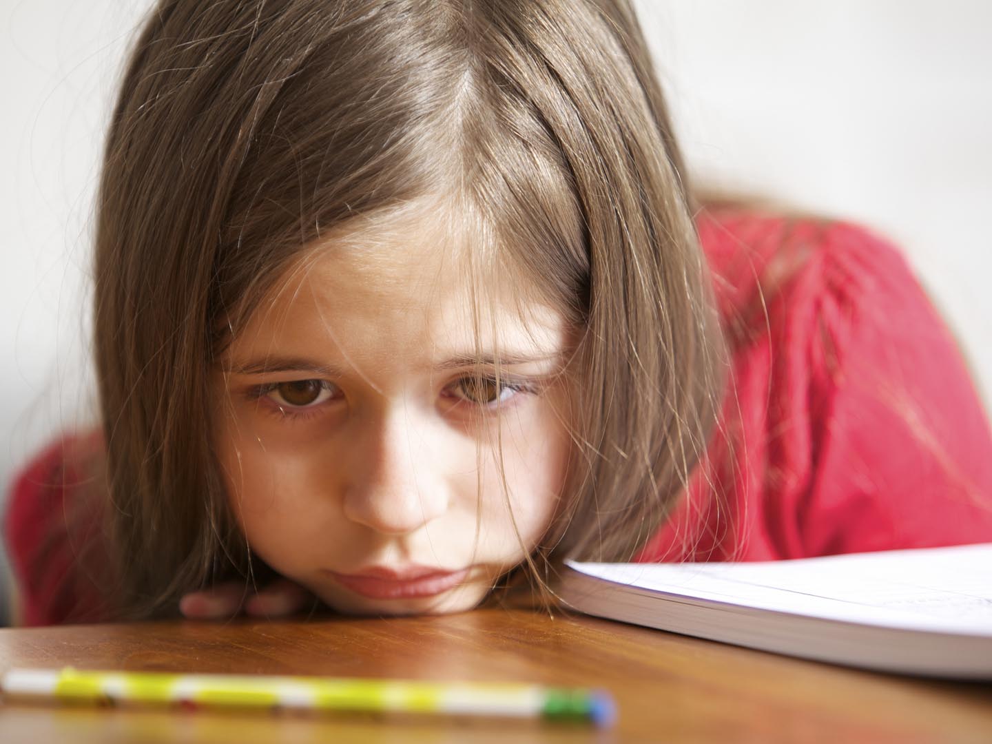 Little student looks sad or bored.