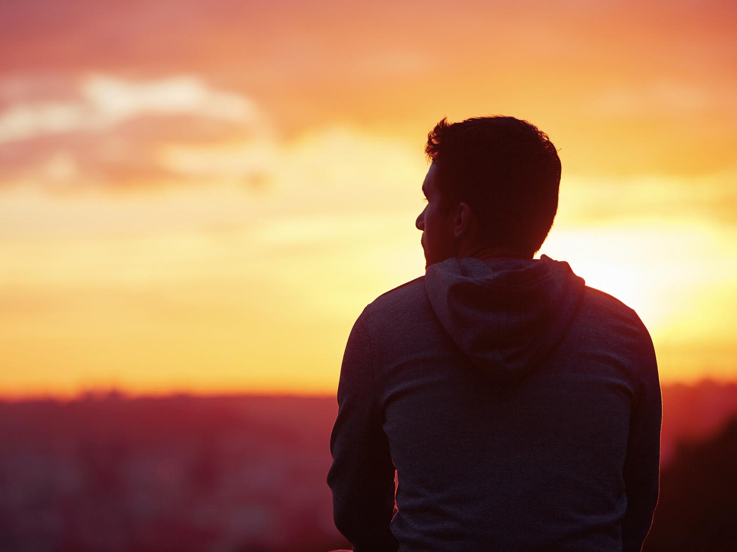 Young man is looking at the sunrise