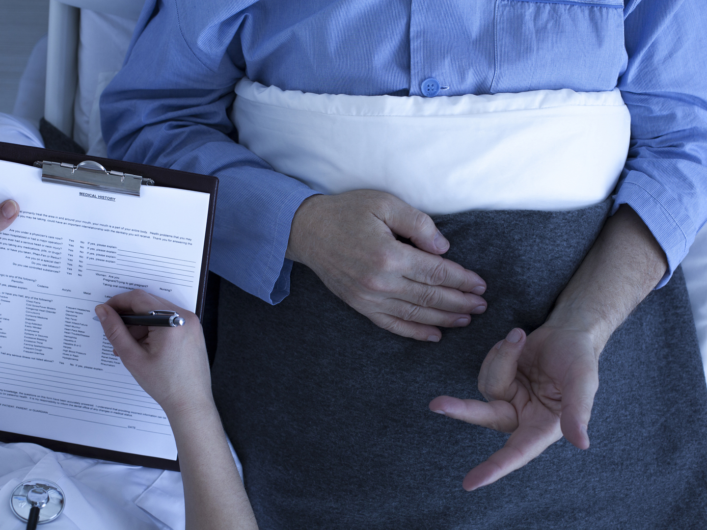 Doctor or nurse talking to patient and reviewing his medical history