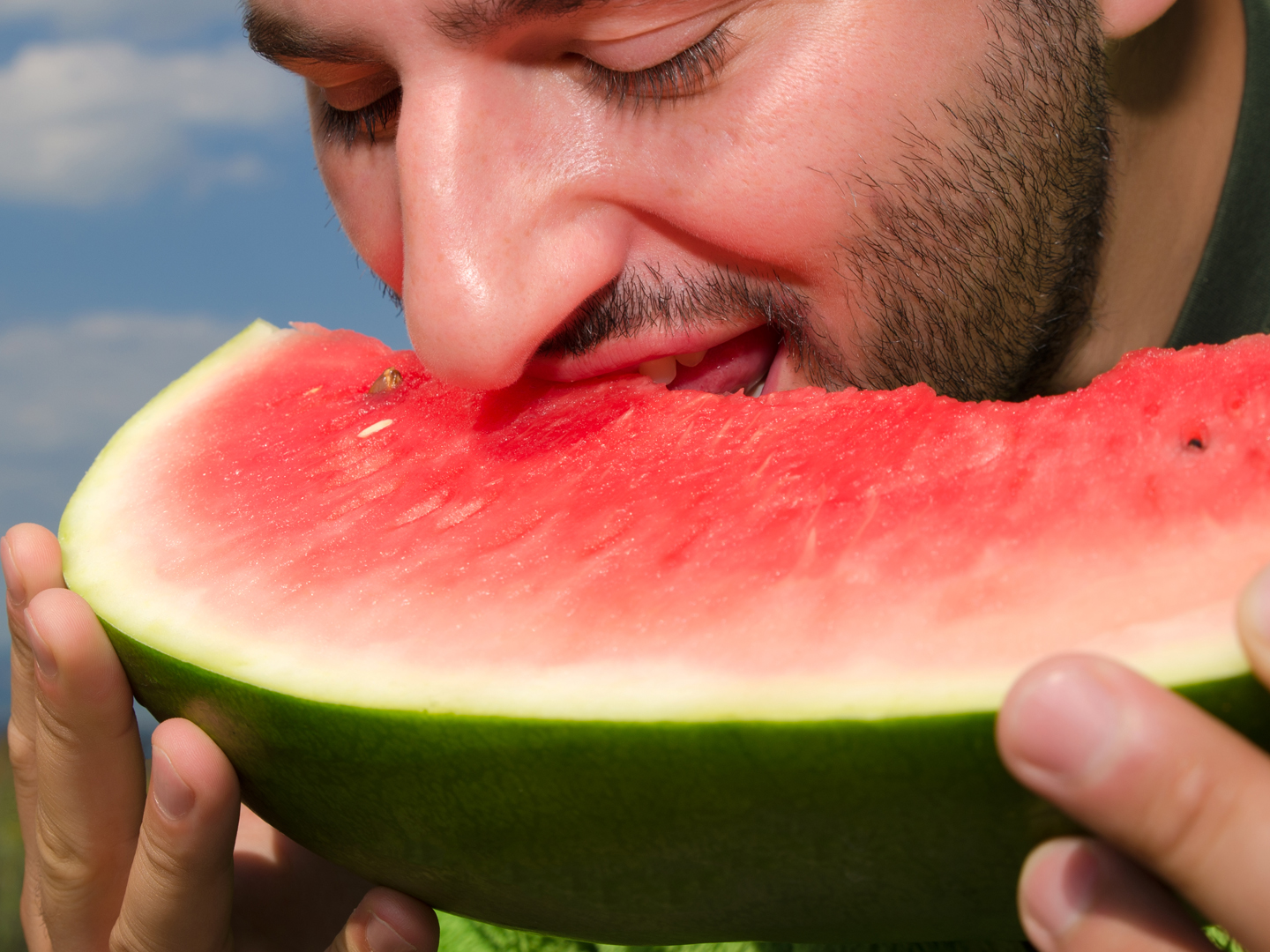 Young man eating watermelon in the Nature