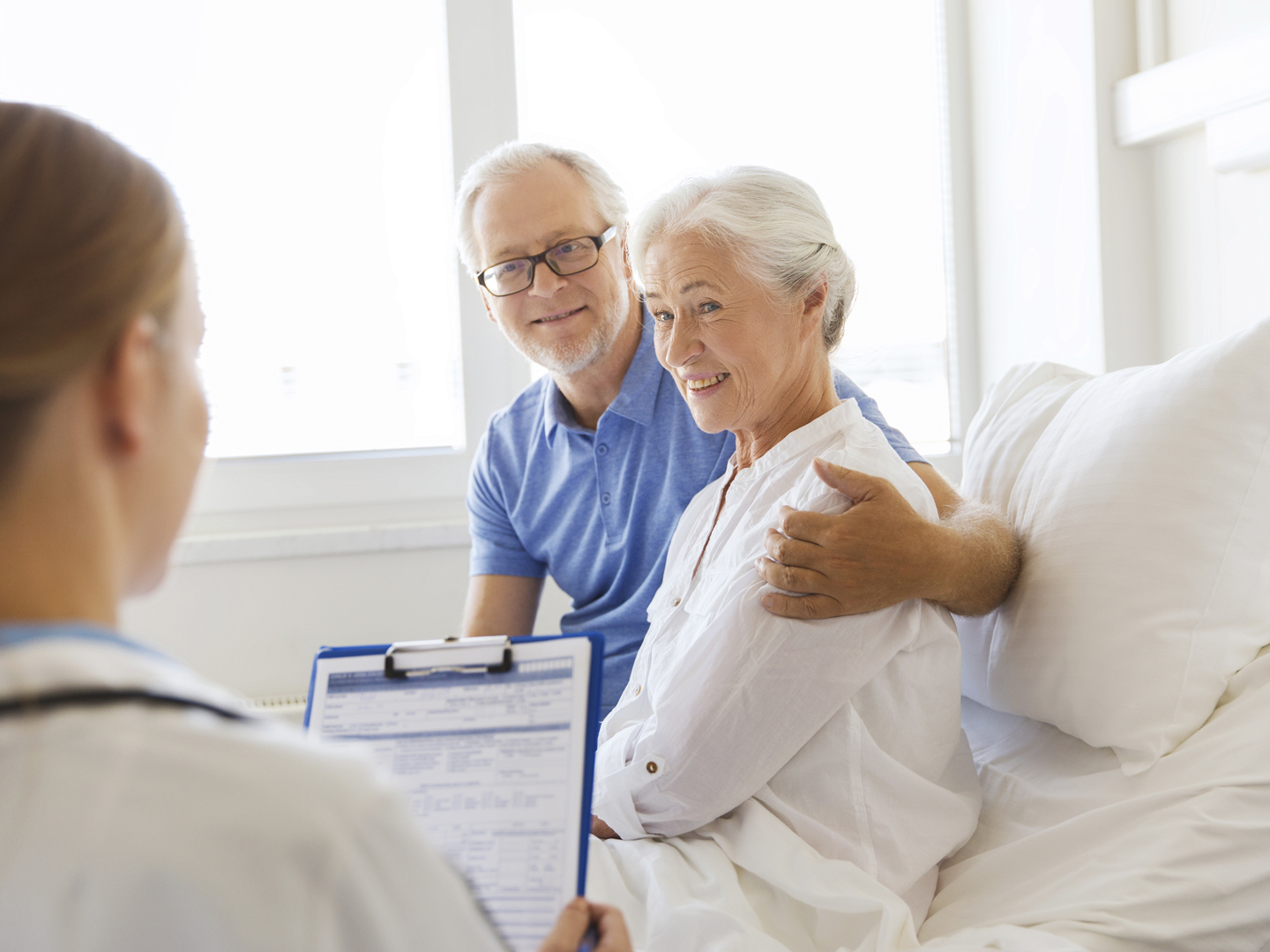 medicine, age, health care and people concept - senior woman, man and doctor with clipboard at hospital ward