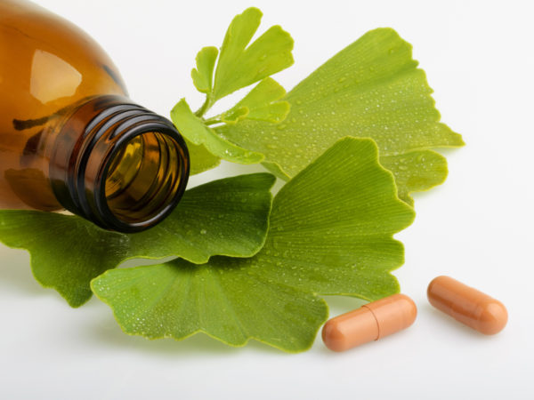 Ginkgo biloba leaves and medicine bottles with pills