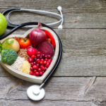 Healthy food in heart and cholesterol diet concept on vintage boards