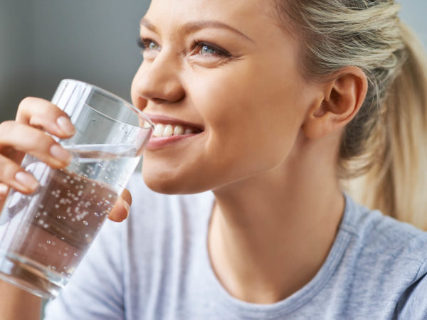 Beautiful young woman drinking water