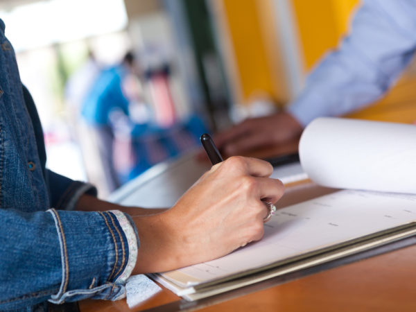 Woman filling out registration form at an event.