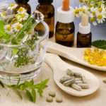 Alternative Medicine. Rosemary, mint, chamomile, thyme in a glass mortar. Essential oils and herbal supplements.