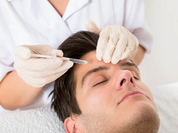 Young Man Having Botox Treatment At Beauty Clinic