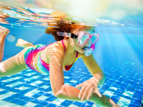 Little girl jumping in the pool