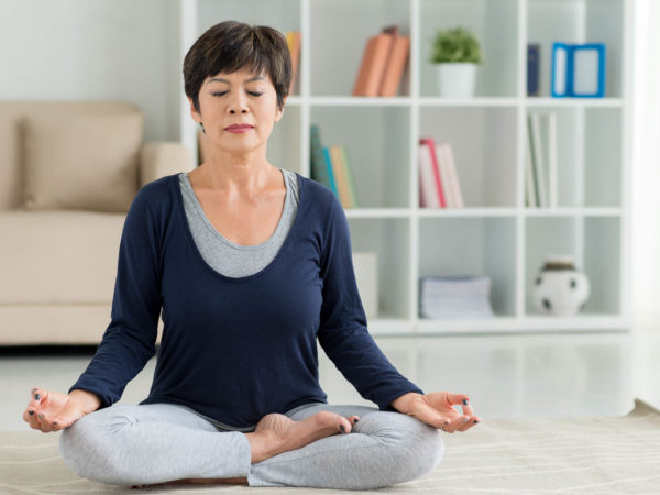 Mature woman sitting on the floor in lotus position