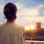 Young girl is watching sunset over Tokyo in Odaiba.