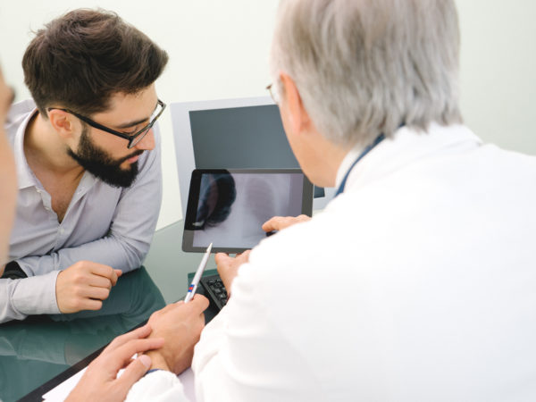 Mature doctor using a digital tablet for his diagnosis.