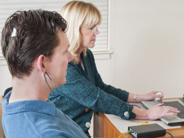 &quot;Psychiatrist with her patient that has electrodes attached to his head, during a session of neurofeedback, which is a type of biofeedback.  Shallow dof with focus on man.Click below for more from this series:&quot;