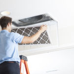 Man cleaning air ducts in home.