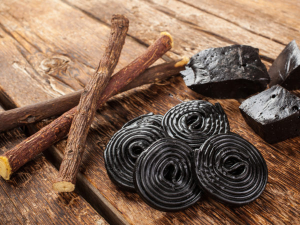 Production steps of licorice, roots, pure blocks and candy on wooden table