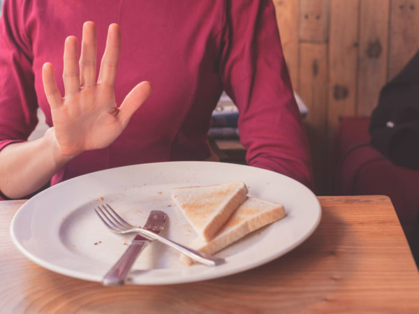A woman on a gluten free diet is saying no thanks to toast