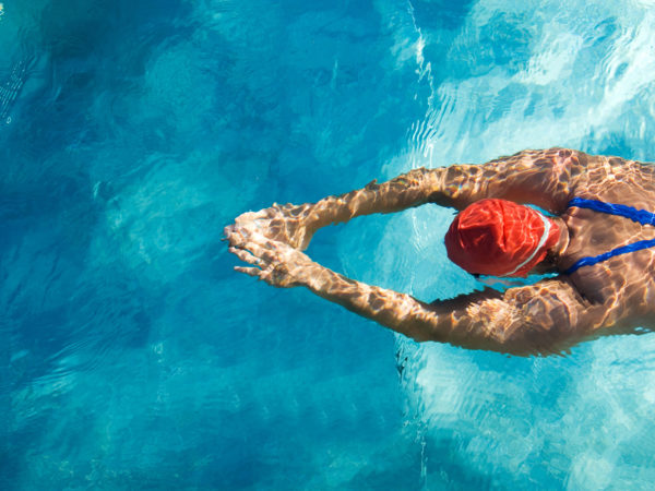 Athletic swimmer is diving in a swimming pool