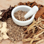 Chinese herb selection with mortar and pestle over mottled background.