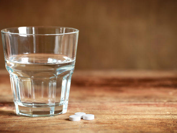 Tablets and a glass on the table.