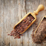 whole and crushed flax seeds on old wooden table