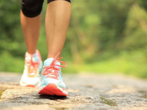 fitness woman hiker feet hiking on stone trail