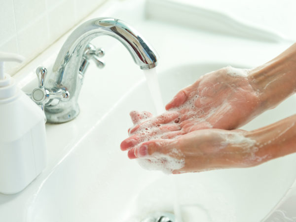 Man washing his hands under running water.