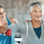Shot of a senior woman using weights with the help of a physical therapist
