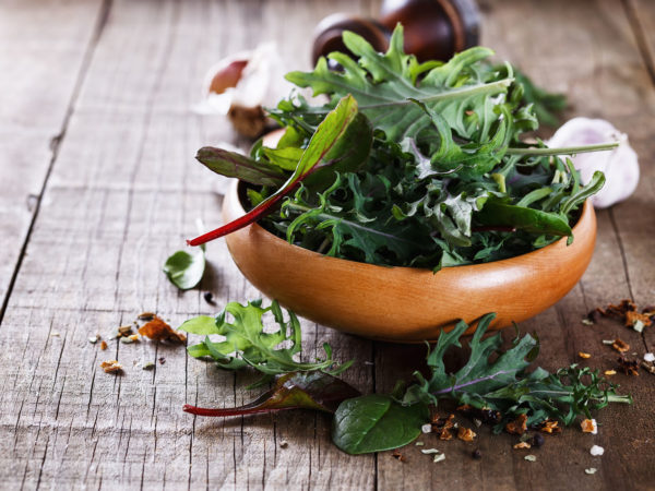 Colon Cancer Awareness: Diet- Leafy green mix over rustic wooden background