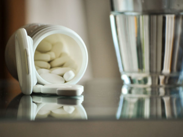 pile of prescription pills with pill bottle