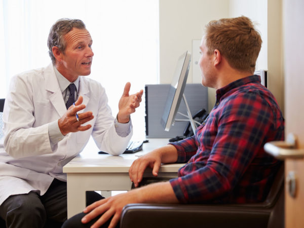 Patient Having Consultation With Male Doctor In Office