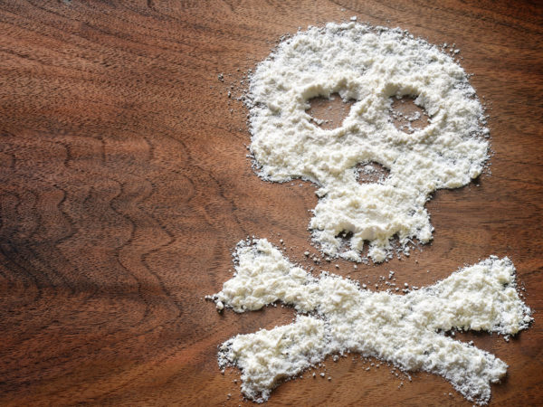 Drug powder cocaine in silhouette of the skull